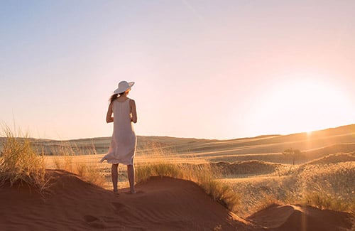 Woman watching sunset in the Namib Desert, Namibia