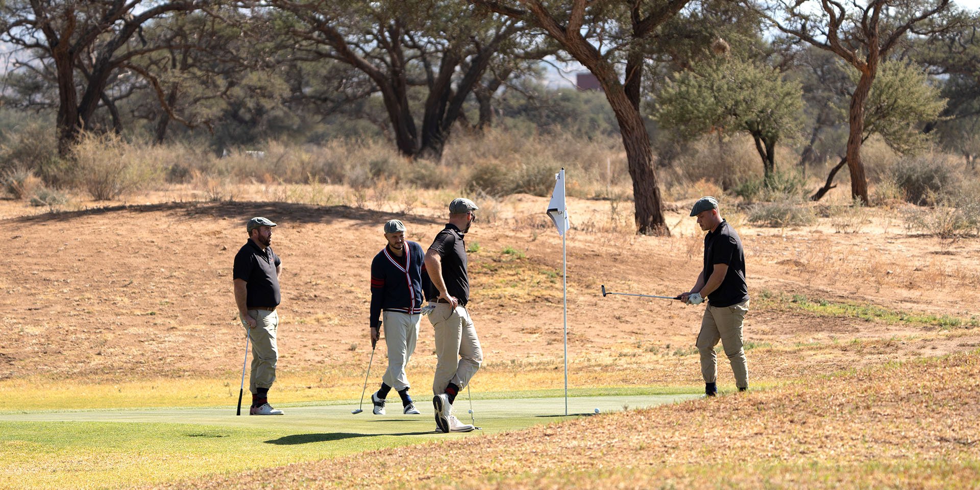 Golfers around hole, Namibia