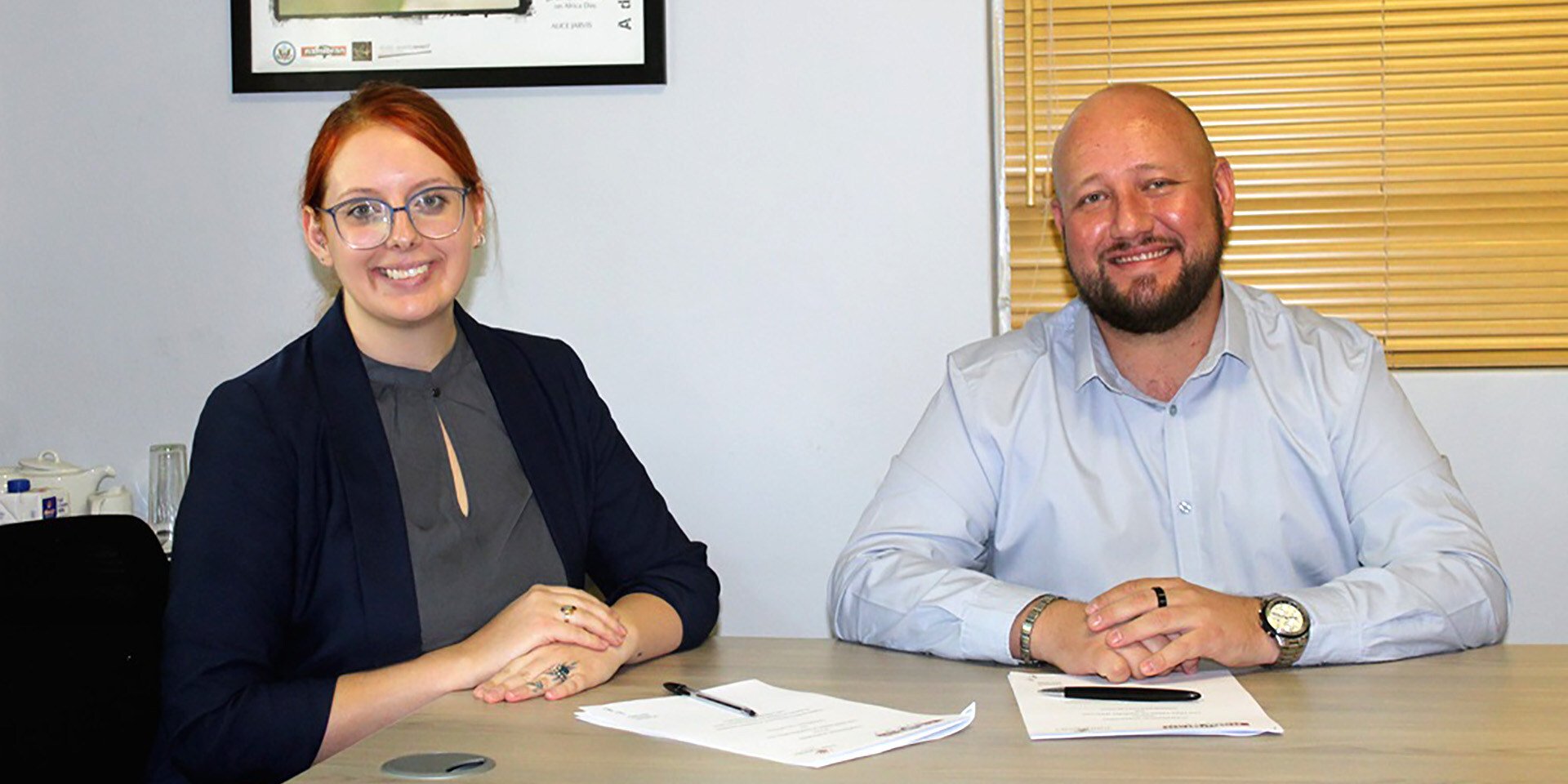 Two people signing a contract