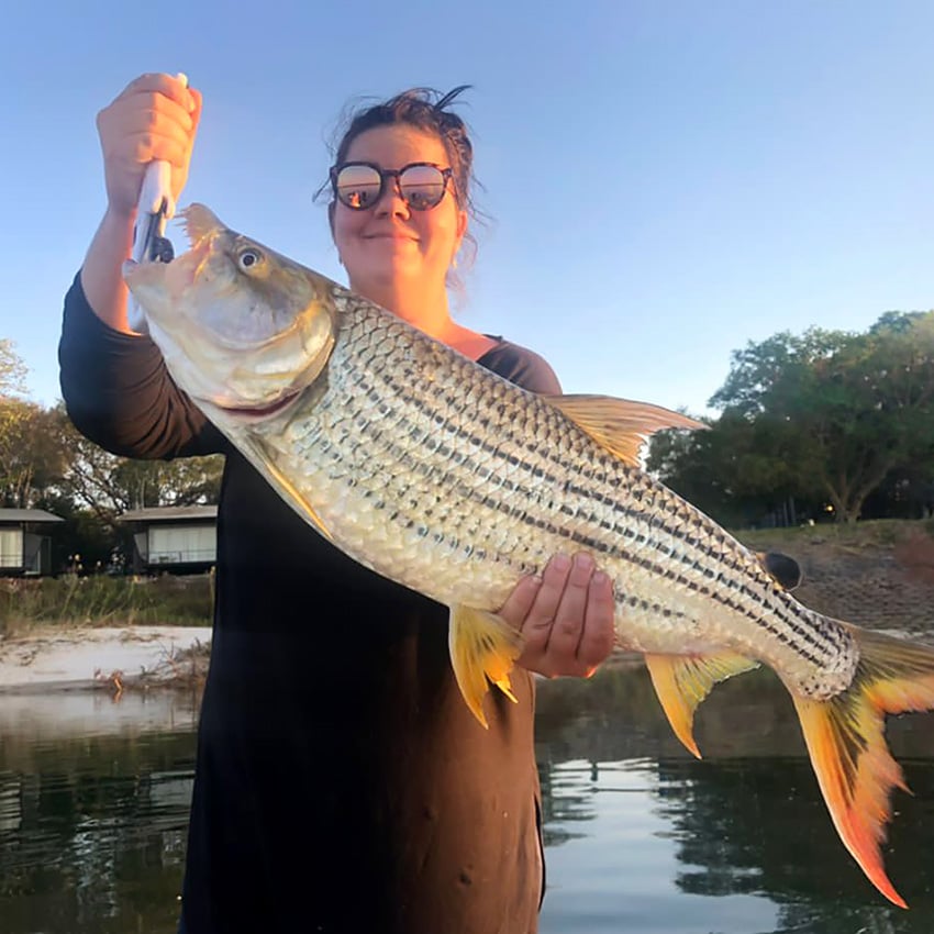 Woman with tigerfish, Zambezi, Namibia